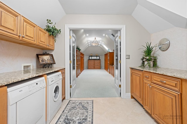 kitchen featuring light stone counters, vaulted ceiling, white dishwasher, light colored carpet, and washer / clothes dryer