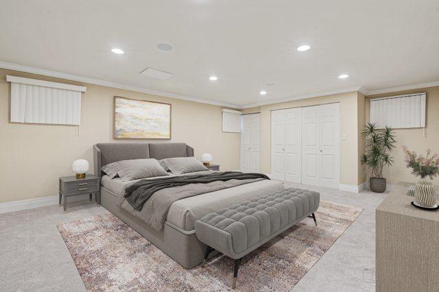 carpeted bedroom with crown molding and two closets