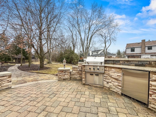 view of patio featuring an outdoor kitchen and a grill