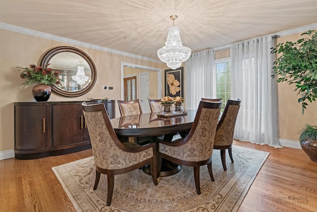 dining area with crown molding, an inviting chandelier, and light wood-type flooring