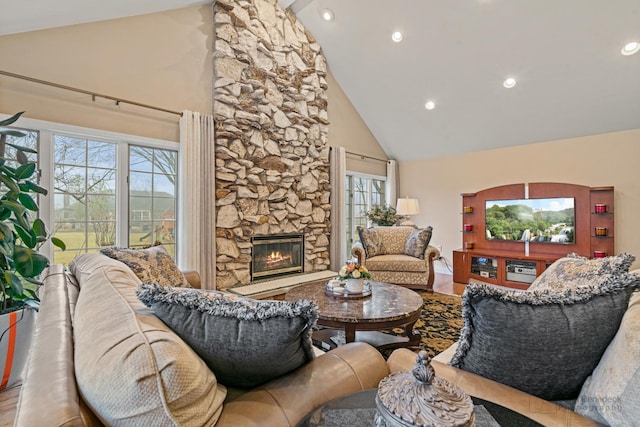 living room featuring high vaulted ceiling, a fireplace, and hardwood / wood-style floors