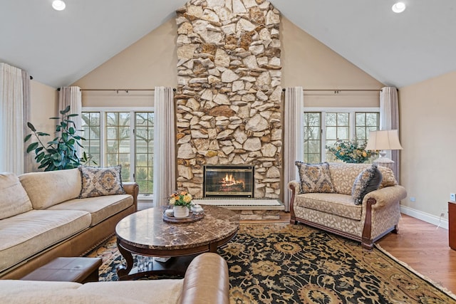 living room with hardwood / wood-style floors, plenty of natural light, a fireplace, and high vaulted ceiling