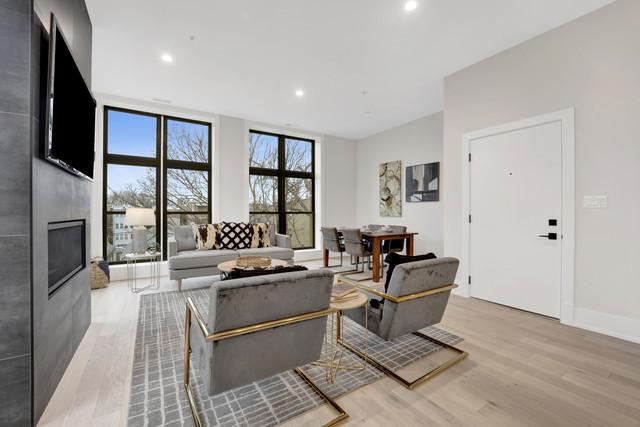 living room featuring a large fireplace, light hardwood / wood-style flooring, and floor to ceiling windows