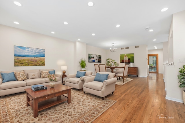 living room featuring a notable chandelier and light hardwood / wood-style floors