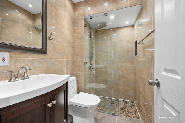 bathroom featuring vanity, tile walls, toilet, and an enclosed shower