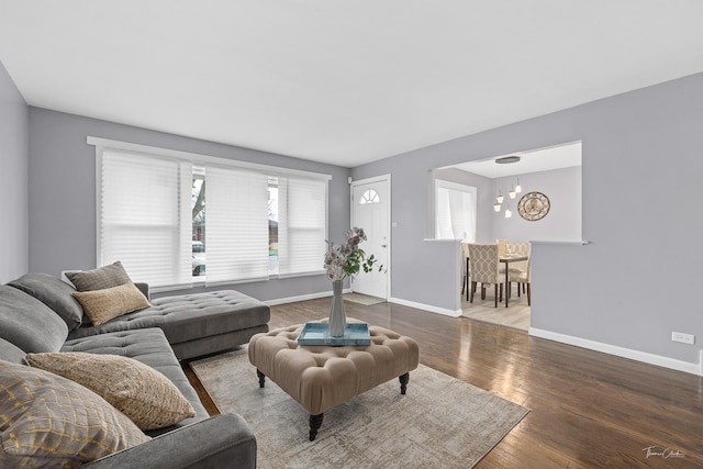 living room with a healthy amount of sunlight, wood-type flooring, and a chandelier