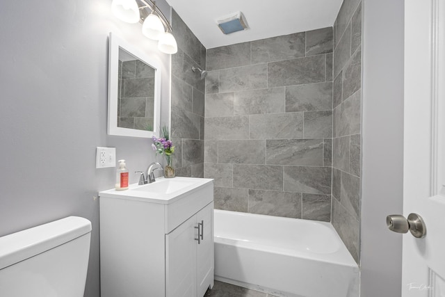 full bathroom with tiled shower / bath combo, toilet, and vanity