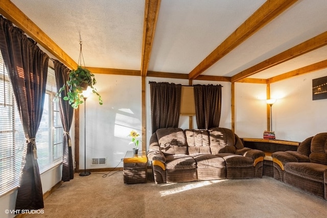 carpeted living room featuring a textured ceiling and beamed ceiling