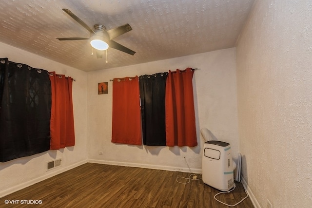 empty room with ceiling fan and dark hardwood / wood-style floors