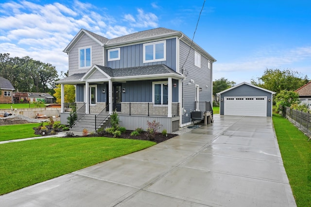 view of front facade with a front yard, a garage, an outbuilding, and a porch