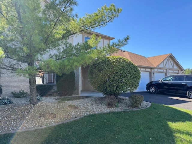 view of front of house with a front lawn, brick siding, and a garage