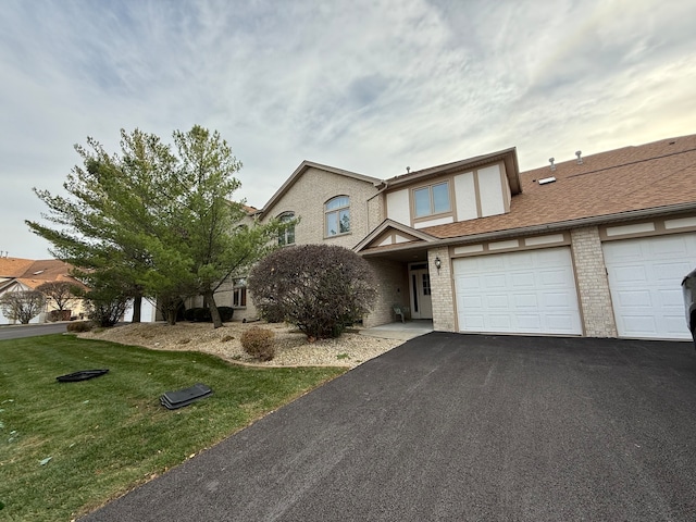 view of front of home with a front yard, stucco siding, a garage, aphalt driveway, and brick siding