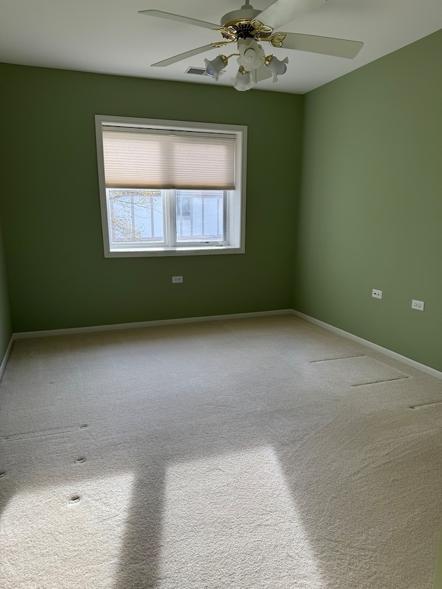 empty room featuring carpet flooring, a ceiling fan, and baseboards