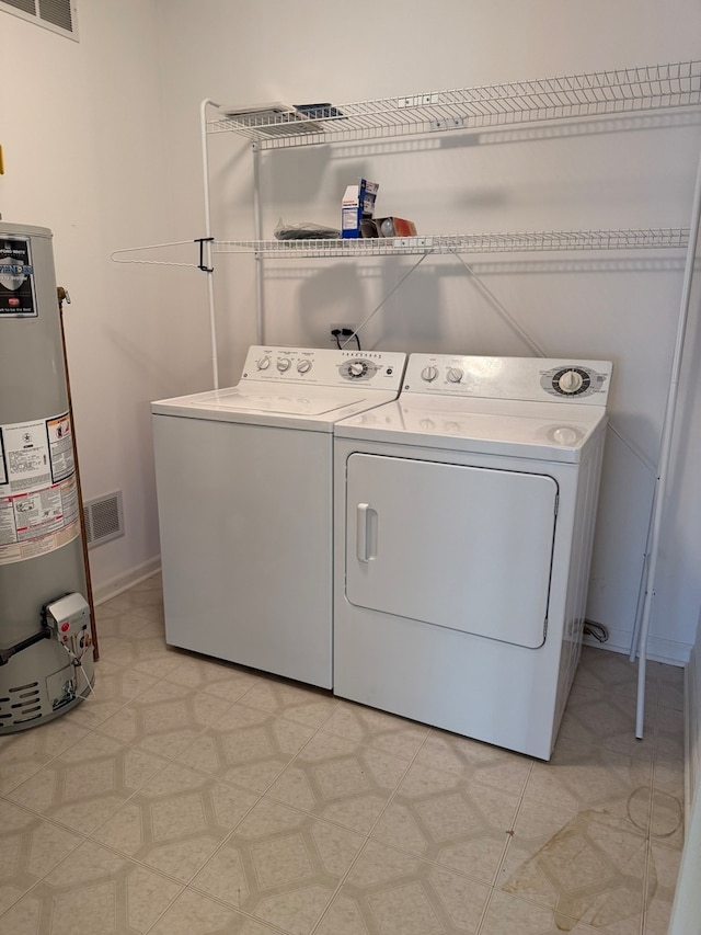 laundry room with light floors, visible vents, washing machine and clothes dryer, laundry area, and water heater