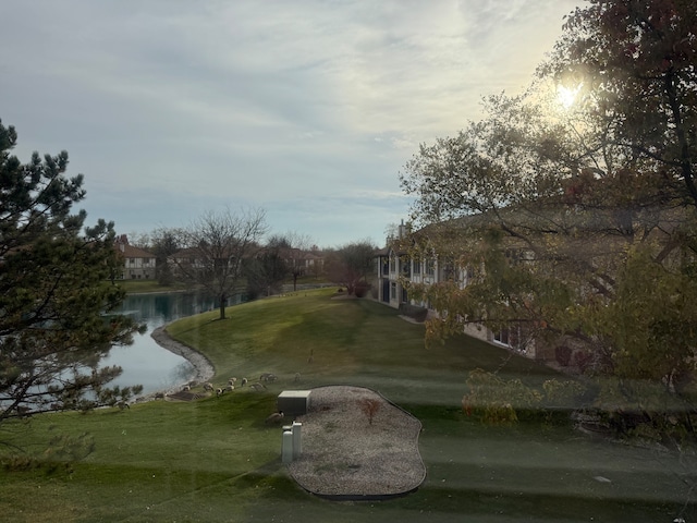 view of property's community with a lawn and a water view