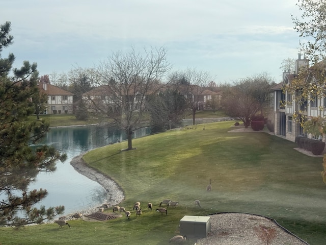 surrounding community featuring a lawn and a water view