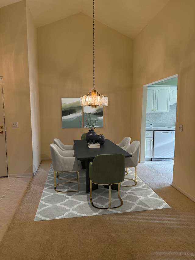 carpeted dining area with high vaulted ceiling and a chandelier