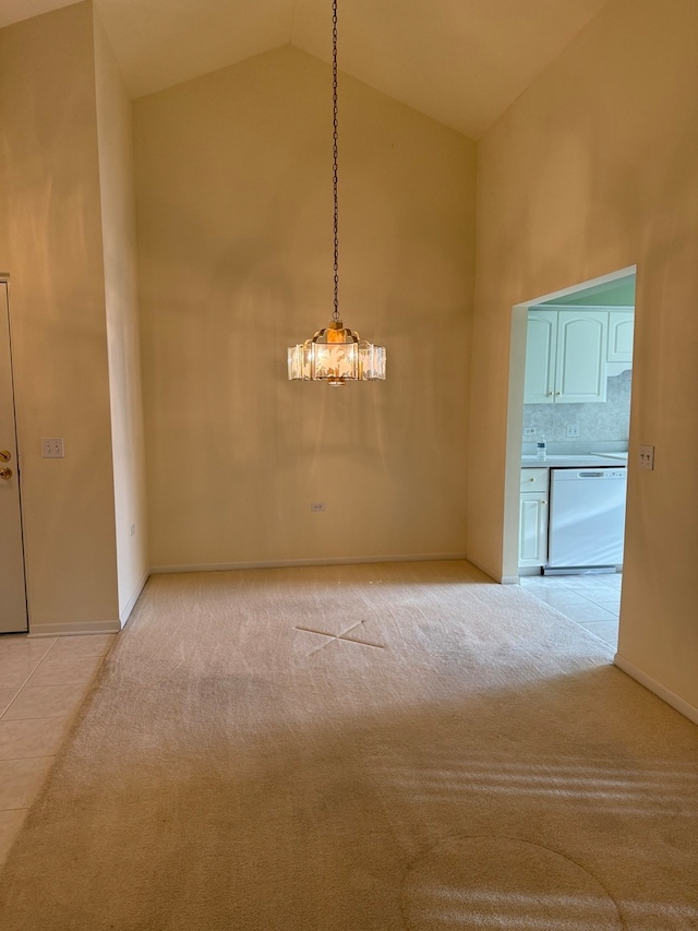 spare room featuring light carpet, baseboards, and high vaulted ceiling