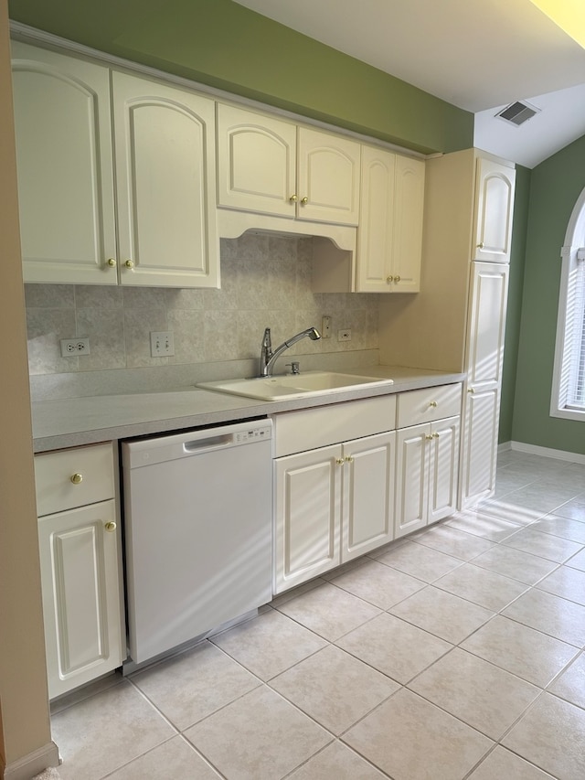 kitchen featuring sink, white dishwasher, light tile patterned floors, and tasteful backsplash