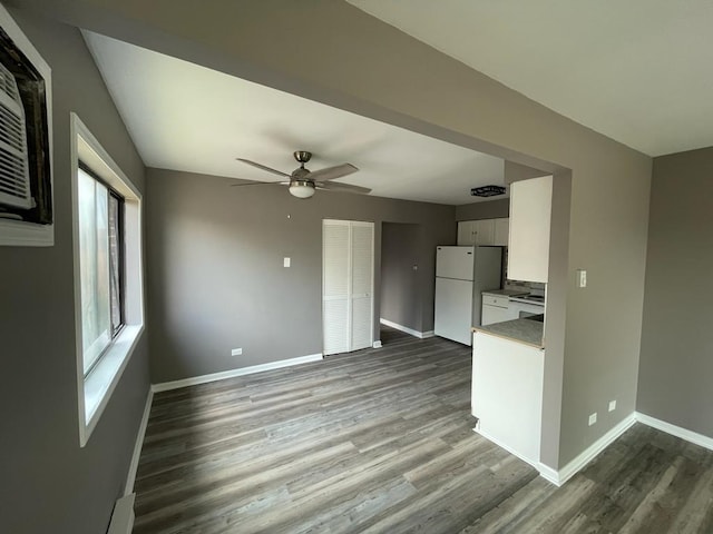 unfurnished living room with dark hardwood / wood-style floors and ceiling fan