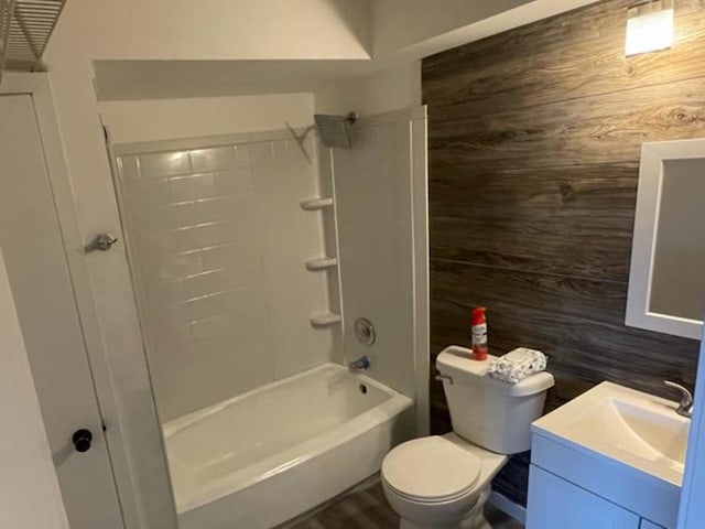 full bathroom featuring vanity, wood walls, toilet, and shower / bathtub combination