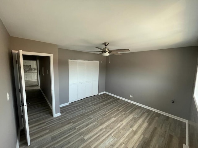 unfurnished bedroom with a closet, ceiling fan, and dark hardwood / wood-style flooring