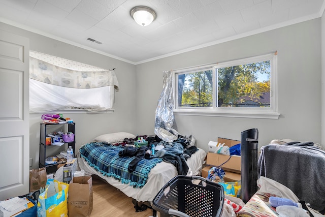 bedroom featuring hardwood / wood-style floors and crown molding