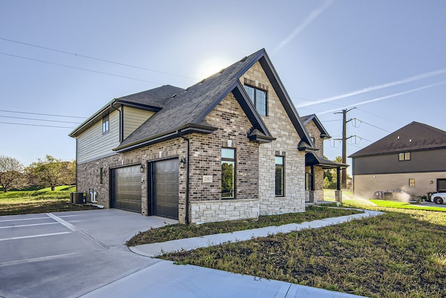 view of side of home with a garage, a lawn, and central AC