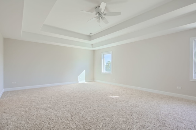 spare room featuring ceiling fan, a raised ceiling, and carpet floors