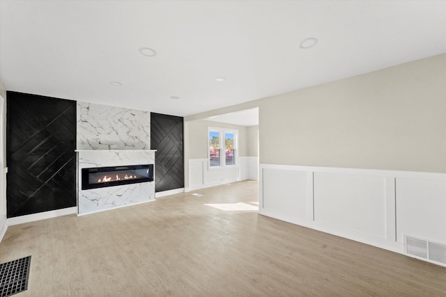 unfurnished living room featuring light hardwood / wood-style floors and a fireplace