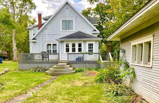 rear view of property with a lawn and a wooden deck