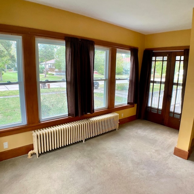 unfurnished sunroom with radiator and a wealth of natural light