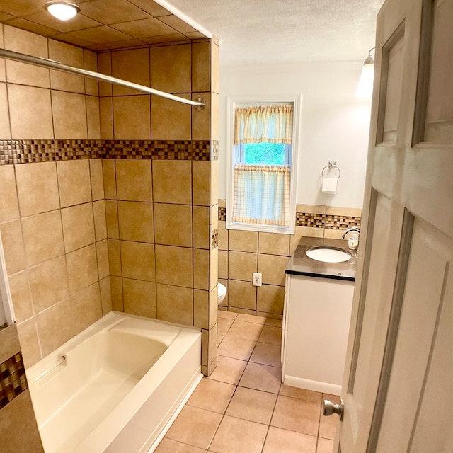 full bathroom featuring tile walls, tile patterned flooring, tiled shower / bath combo, vanity, and toilet