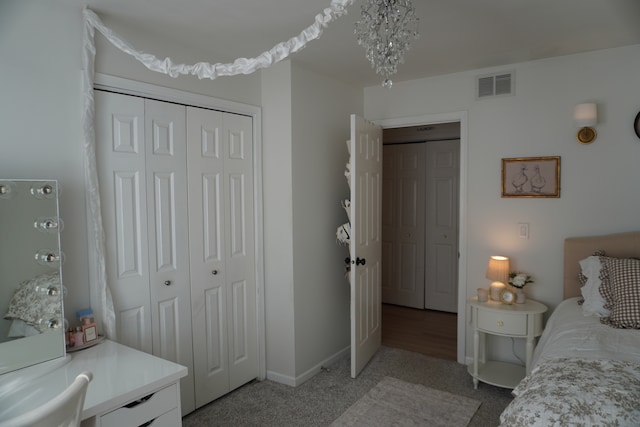 carpeted bedroom featuring an inviting chandelier and a closet