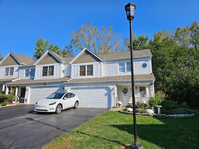 multi unit property featuring a front yard, a porch, and a garage