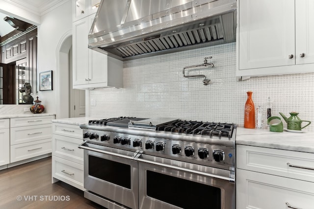 kitchen featuring range with two ovens, dark hardwood / wood-style flooring, exhaust hood, and white cabinetry