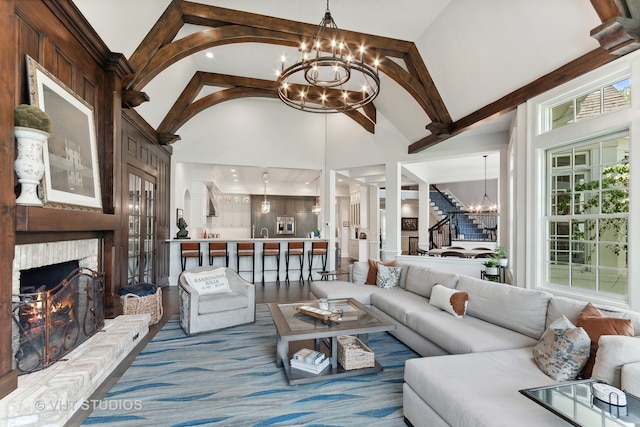 living room with hardwood / wood-style flooring, high vaulted ceiling, and a large fireplace