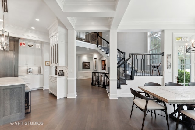 dining space featuring beam ceiling, coffered ceiling, dark hardwood / wood-style floors, a notable chandelier, and crown molding