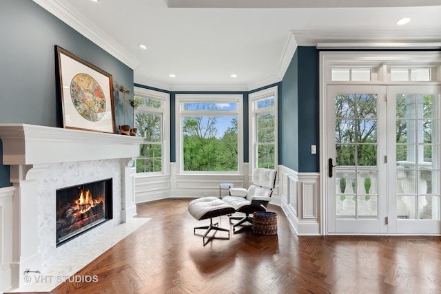 sitting room with ornamental molding and parquet floors