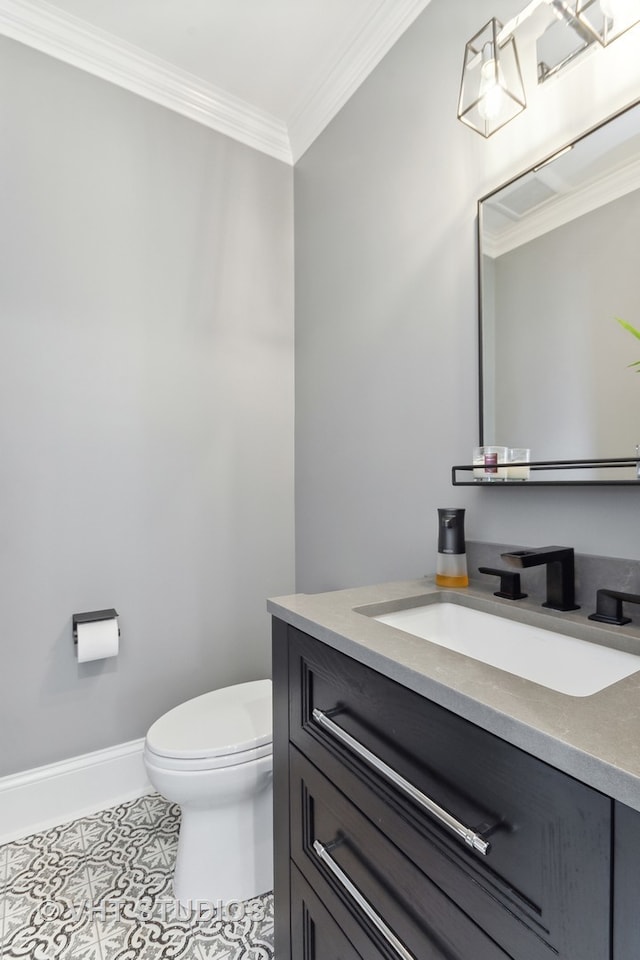 bathroom with ornamental molding, vanity, toilet, and tile patterned floors