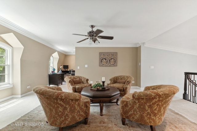 carpeted living room with ornamental molding and ceiling fan