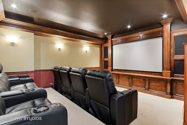 home theater room with decorative columns, crown molding, and carpet flooring