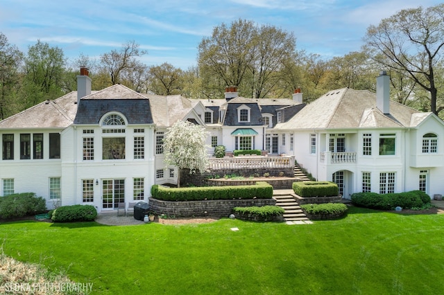 back of property featuring french doors and a lawn