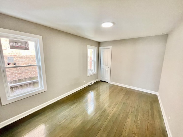 unfurnished room with dark hardwood / wood-style flooring