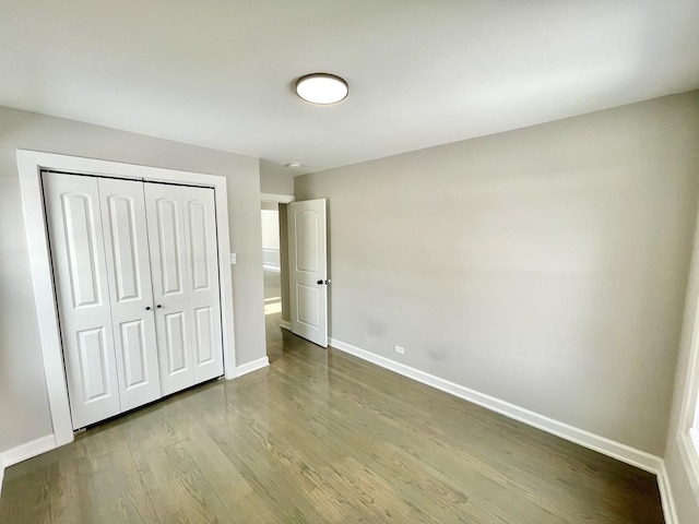 unfurnished bedroom with hardwood / wood-style floors and a closet