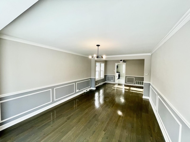 unfurnished living room with dark hardwood / wood-style floors, crown molding, and a notable chandelier