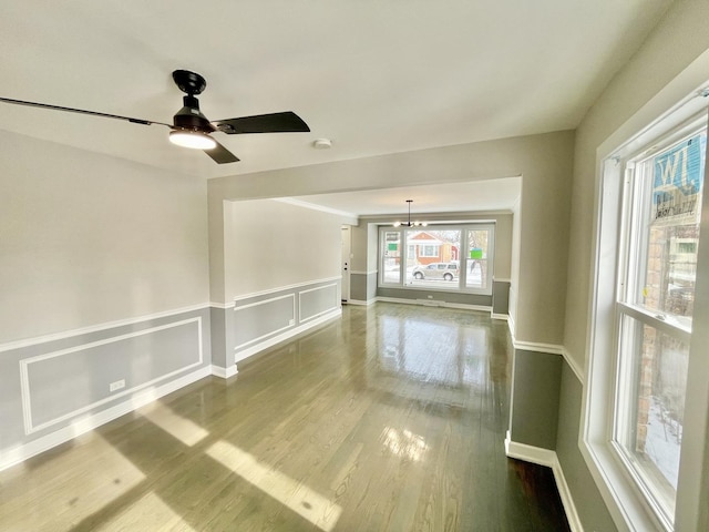 empty room featuring hardwood / wood-style floors and ceiling fan with notable chandelier