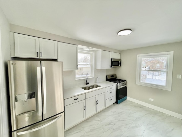 kitchen with sink, white cabinetry, and stainless steel appliances