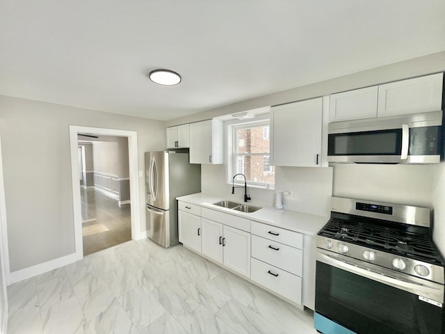 kitchen featuring white cabinetry, sink, and appliances with stainless steel finishes