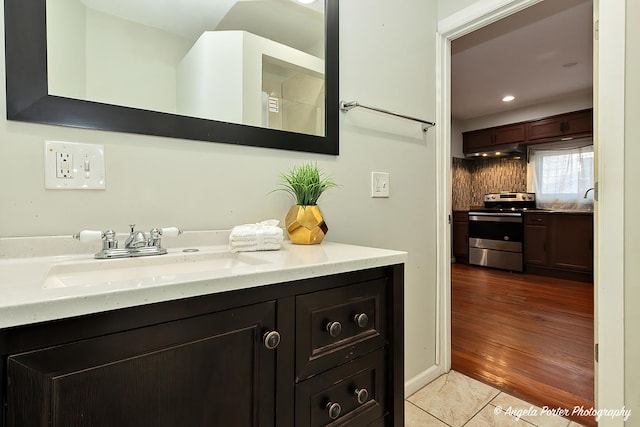 bathroom with decorative backsplash, vanity, and hardwood / wood-style flooring